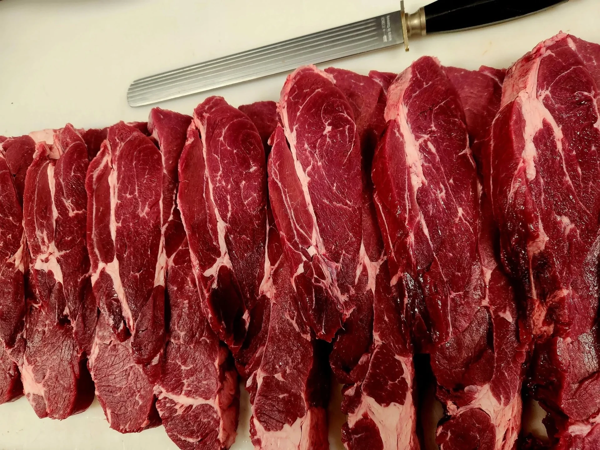 Freshly sliced grass-fed beef steaks on a butcher's block at Bianchi's Butchery Cooktown