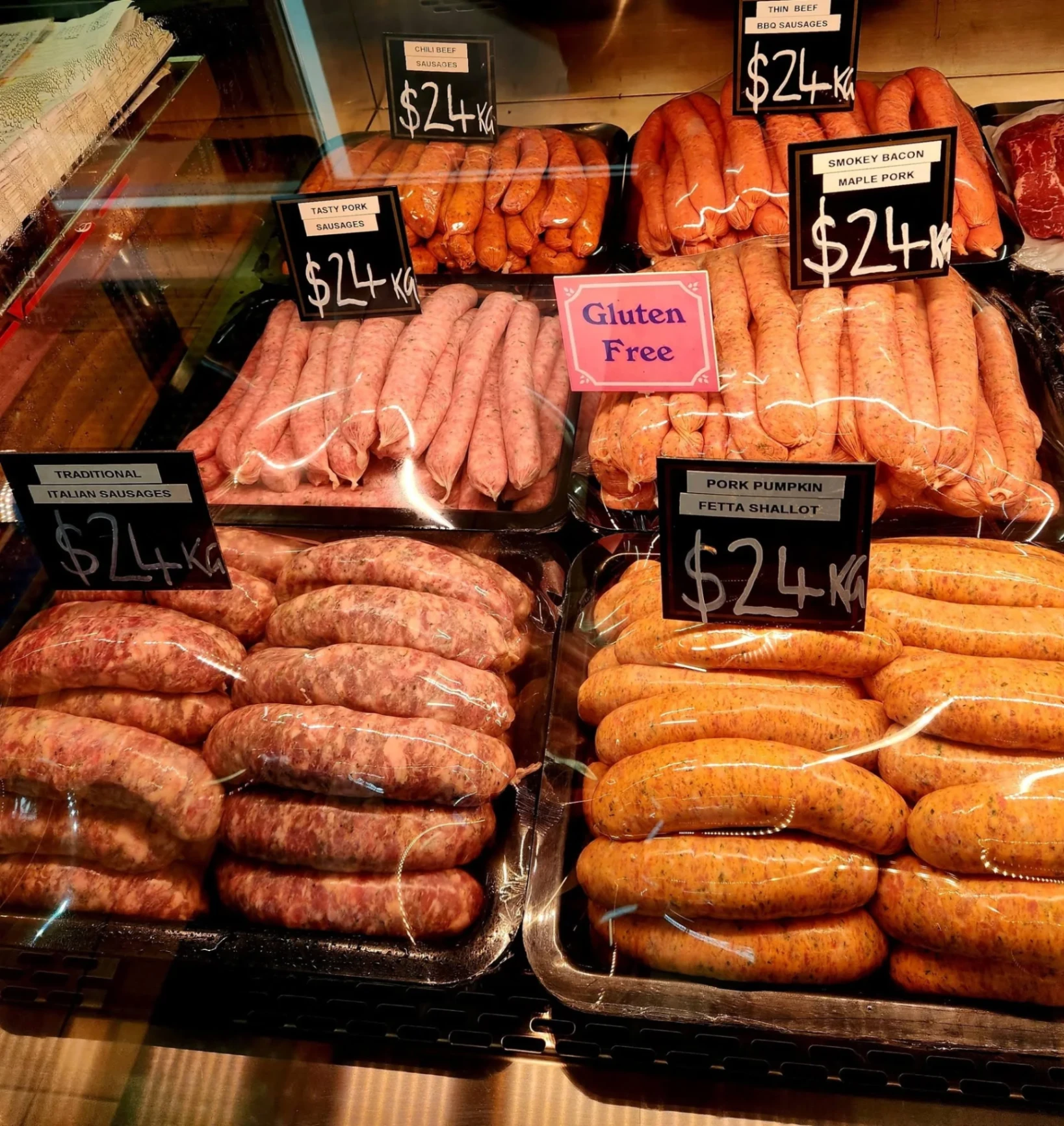 A coil of fresh handmade sausages with a Bianchi's Butchery Cooktown business card